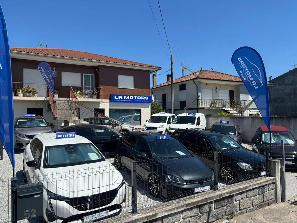 Stand da LR Motors em Vila Verde, com viaturas em exposição e a tabuleta da marca